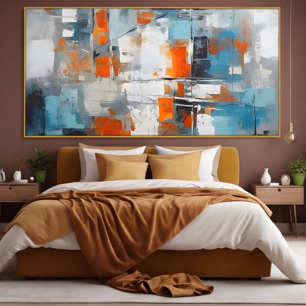 Tablou canvas cu pictura abstracta cu blocuri portocalii si albastre, in rama de aluminiu auriu, pe perete intr-un dormitor